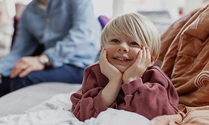 Five tips for buying a new TV:  Happy kid and his family in the background.