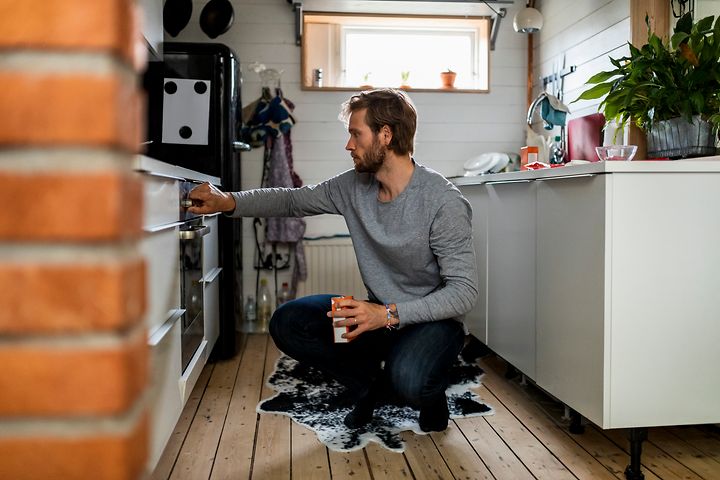 Mann som sjekker stekeovnen
