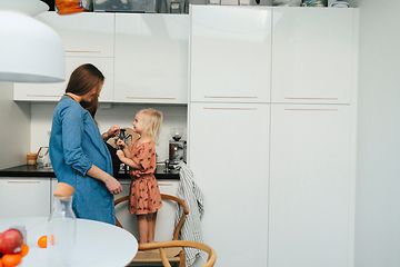 Gravid kvinne og barn på kjøkken