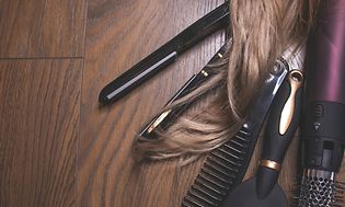 Forskjellige hårstylings-produkter ved hår som rettetang, kam, børste og varmluftsbørste