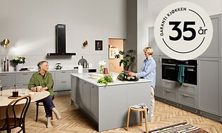 To kvinner i et Epoq-kjøkken og en 35 års garanti-logo