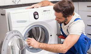 MDA-Vaskemaskin-fagperson som fikser en ødelagt vaskemaskin