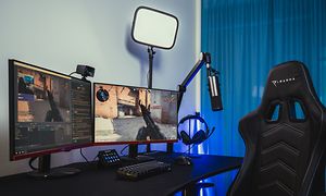 Streamingoppsett på gamingstasjon med to skjermer som viser et skytespill