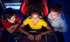 Tre barn som spiller på en datamaskin 