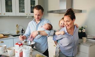 en familie lager mat sammen i deres kjøkken
