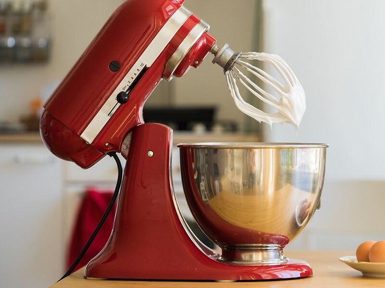 KitchenAid kjøkkenmaskin på kjøkkenbenk med egg og boks med sukker