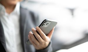 nærbilde av en business-vkinne som holder en svart iPhone 12 Pro Max
