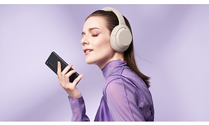 En kvinne som bruker hodetelefoner og holder en Xperia 10
