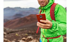 en mann med mobiltelefon på fjelltur