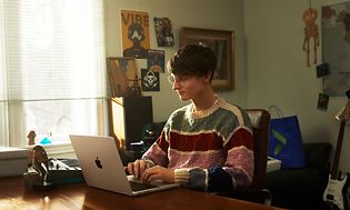 en tenåring jobber på en MacBook Pro