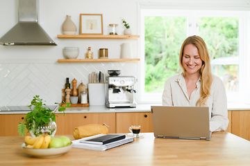 Woman using laptop in kitchen