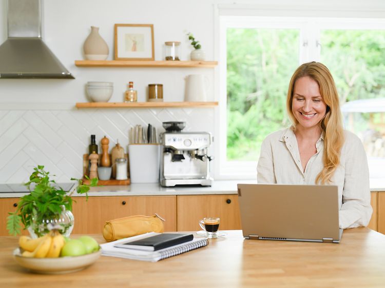 Woman using laptop in kitchen