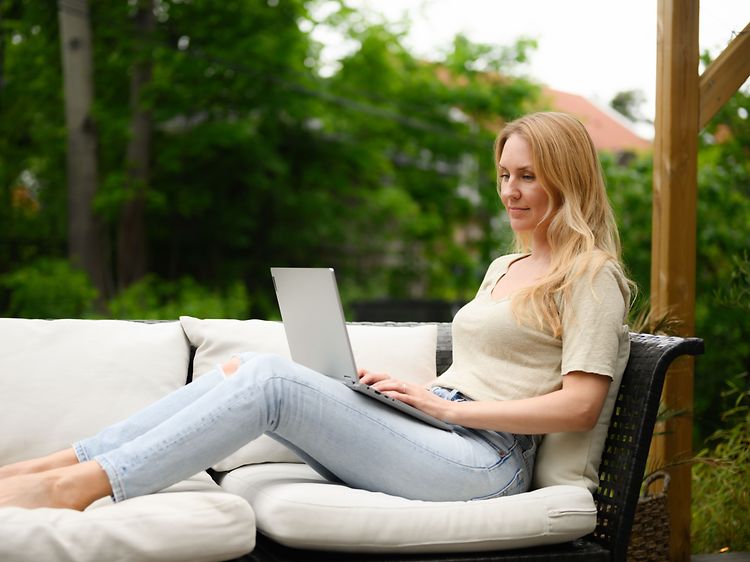Woman using her laptop on a porch