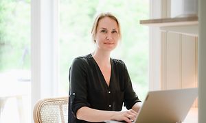 Woman working on her laptop in front of a table