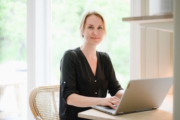 Woman working on her laptop in front of a table