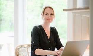 Woman working on her laptop in front of a table