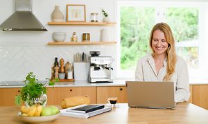 Woman working on her laptop in a kitchen
