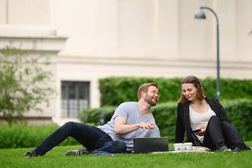 Man and woman with laptop in park