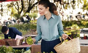 Woman at a farmers market picking out vegstables