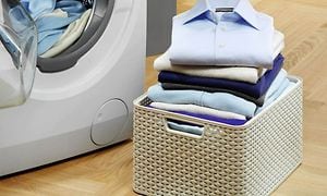 Basket full of folded laundry next to a washing machine