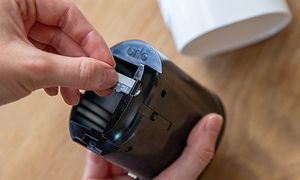 Hånd som setter inn et sim-kort i et Arlo Go V2 sikkerhetskamera