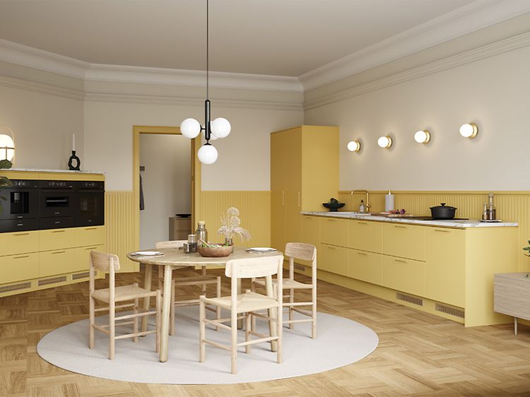 Åpent gult Epoq-kjøkken i fargenTrend Mellow med rundt spisebord i midten