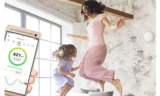 airthings-app på smarttelefon undersøker inneklima mens barn leker