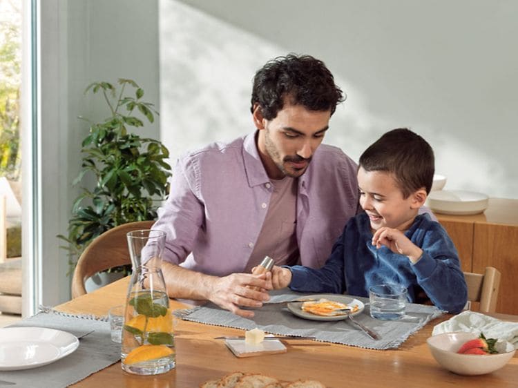 Man and child sitting at a dinner table eating (1)