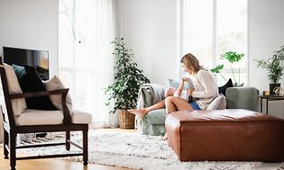 Woman and baby sitting on a couch in the living room