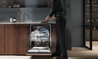 Man taking out the dishes from an Electrolux dishwasher 