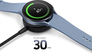En Samsung Galaxy Watch5 som er koblet til en ledning og lader