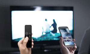 fjernkontroll og app på smarttelefon peker mot tv-skjerm