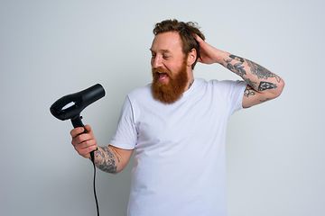 Man singing into hair blower