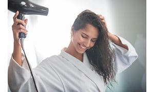 SDA-Smiling woman in robe blowing her hair