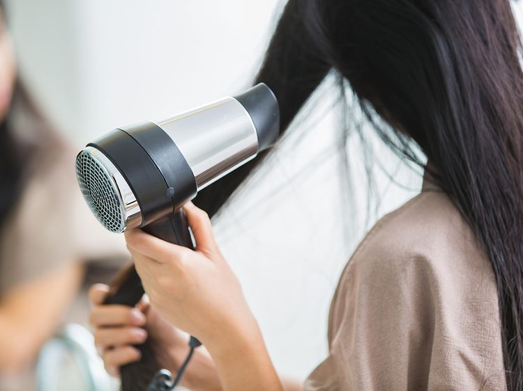 SDA-Woman blowing her hair next to mirror