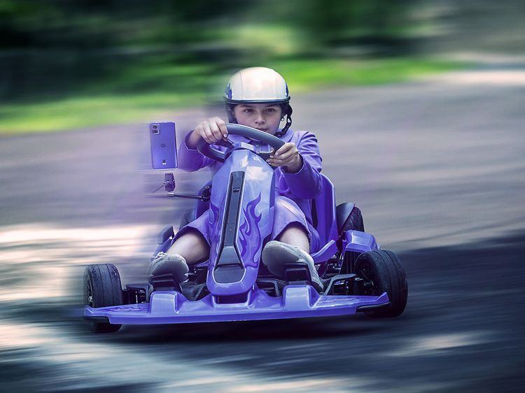 Mann som kjører en Gocart i en lys lilla farge samme som Motorola Edge 30 Neo