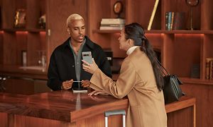 Woman at a hotel reception holding a Google Pixel 7 Pro