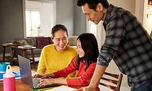 Familie som sitter rundt en Acer Spin Chromebook på kjøkkenet
