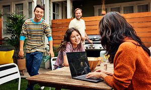 Familie som sitter ute med en Acer Spin Chromebook