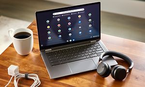 Acer Spin Chromebook som viser skrivebordet med kaffe og hodetelefoner rundt