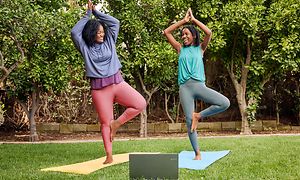 To kvinner som driver med yoga og ser på en Lenovo Chromebook utendørs