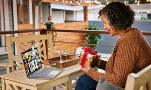 Eldre kvinne videochatter med HP X360 Chromebook og holder en gave