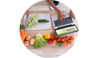 Laptop på en benk med grønnsaker