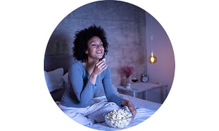 kvinne som spiser popcorn i sengen
