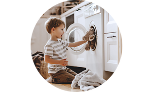 Levering - Barn som putter bamse i vaskemaskin