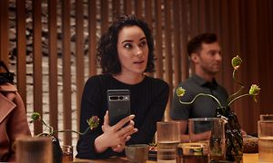 Woman in restaurant holding Pixel phone