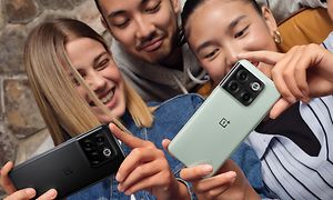 Tre venner ser på en OnePlus 10T-telefon sammen