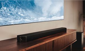 Samsung Q- Series Soundbar under en veggfestet TV i en stue