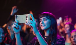 Kvinne som står på en konsert og filmer på Google Pixel 7 Pro