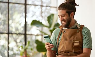 Man in apron holding a Pixel 6a